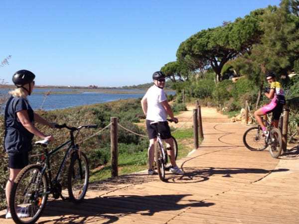 Three people on bycicles, on the countryside