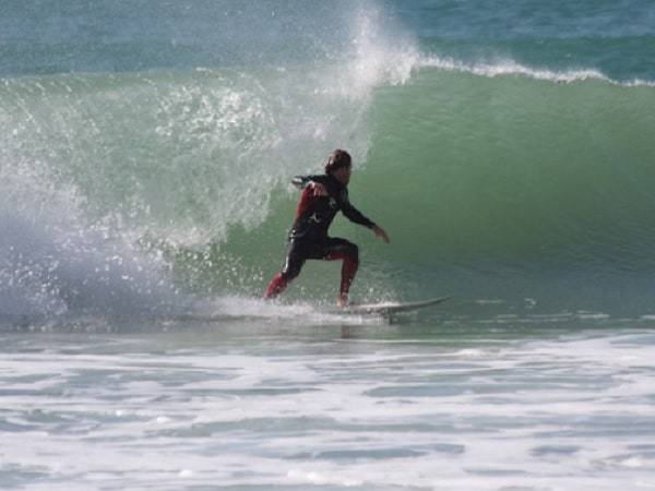 Man surfing a big wave, from left to right.