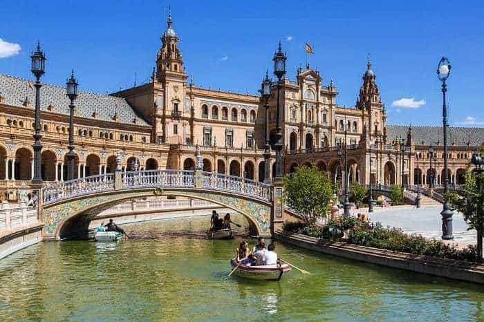 seville cathedral with bosts on the river and small bridge